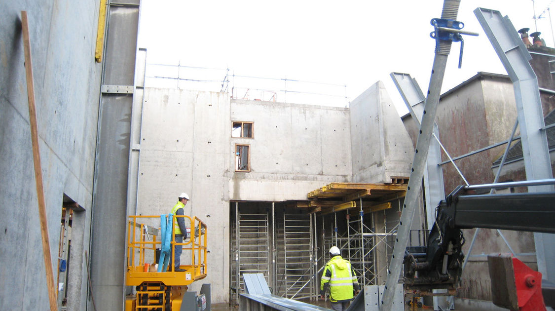 Chantier du pôle Max Jacob : Les charpentiers utilisent des élévateurs pour aller assembler et arrimer la structure métallique dans les parois béton. Le 29 janvier 2013